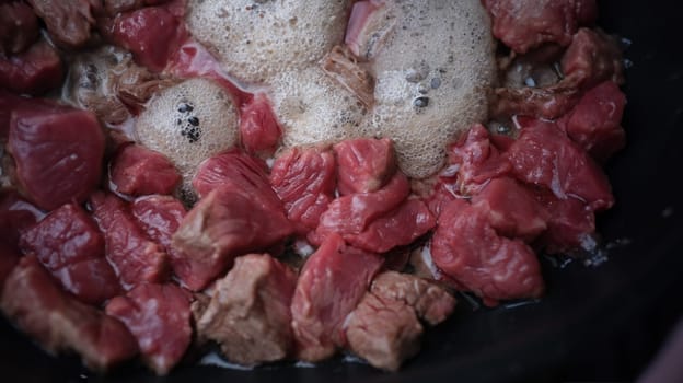 Pieces of pork or beef are fried in pan in oil. Recipes for fried and stewed meat in pan concept