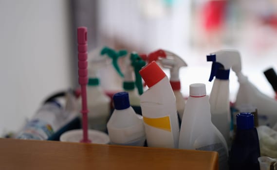 Lot of plastic bottles with detergents are on shelf in bathroom closeup. Cleaning of offices and apartments concept