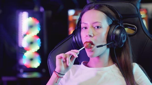 Girl gamer with plump lips sucking a lollipop, portrait