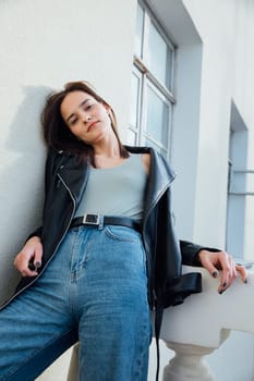 Woman in jeans posing on balcony room