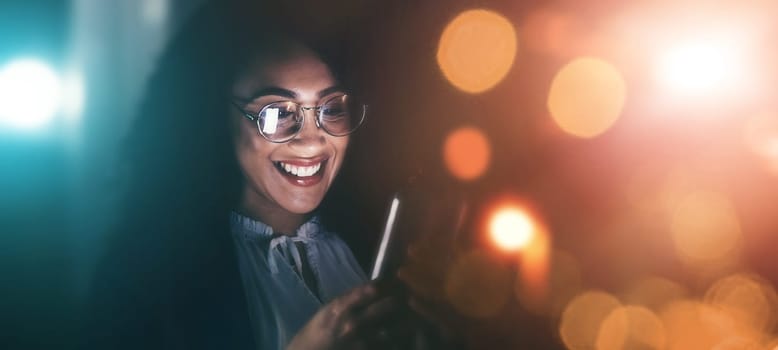 Businesswoman, phone and smile in communication at night for texting, chatting or networking on dark background. Happy female employee holding smartphone working late for online planning strategy.