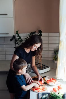 housewife with son cooking food dinner in kitchen