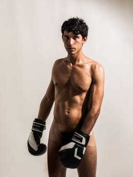 A totally naked young athletic man with no shirt wearing boxing gloves. A Handsome, Athletic Young Man Ready for Action