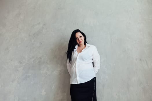 Portrait of a brunette woman in a white business suit