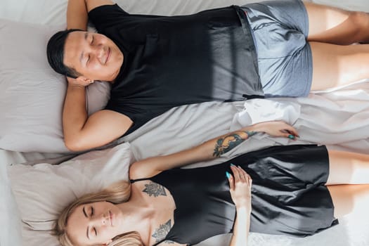 Husband and wife sleeping together in bed