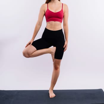 Beautiful woman doing Lotus of Padmasana or Kamalasana pose on a yoga class. Studio shot.