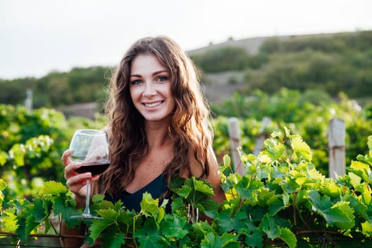 woman with a glass of wine in a vineyard