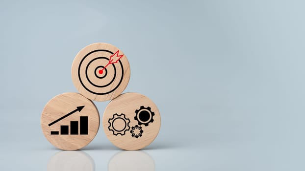 Circular wood with printed target icons and business symbols on white background, business goals and objectives concept, business competition.