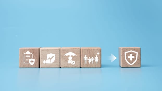 Concept of health insurance and medical. Wooden block with icons about health insurance and access to health care, health care planning on a blue background.