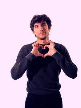 A man making a heart with his hands, in studio shot on neutral background