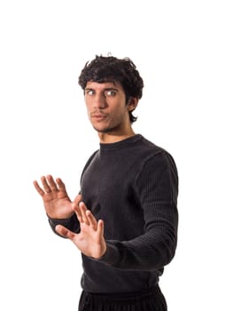 A man in a black sweater is making a hand gesture as saying: wait, stop there, caution, wait a moment, slow down