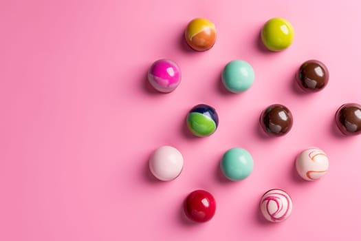 An assortment of homemade chocolate bonbons on the pink background. Modern hand painted chocolate candy. Product concept for chocolatier. AI generation