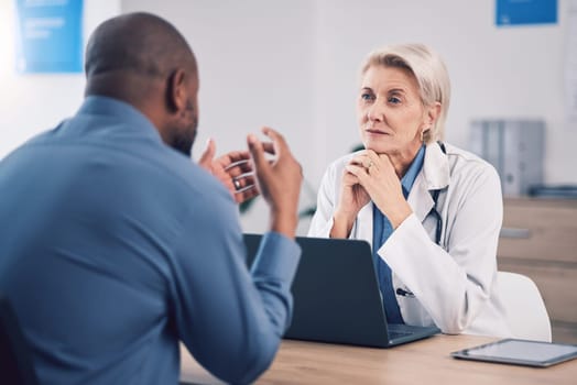 Woman, doctor and listening to man in consultation for healthcare advice at clinic. Mature medical professional consulting with patient for support, wellness services and communication in hospital.