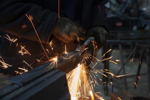 The grinder cuts iron and sparks of fire fly.