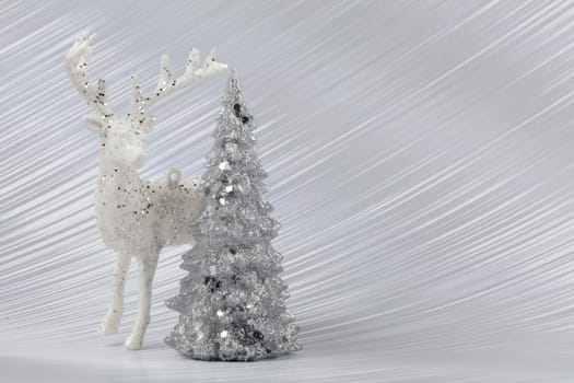Christmas or New Year background with silver snowy fir tree and deer. Bright festive background.