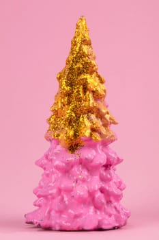 Christmas composition. Pink Christmas tree with gold on a pink background. Happy Holidays. minimal new year concept.