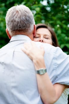 Senior couple, nature and a hug for love, care and bonding together in retirement. Comfort, elderly and a man and woman with affection, romance or loyalty in a marriage in a garden or park for a date.