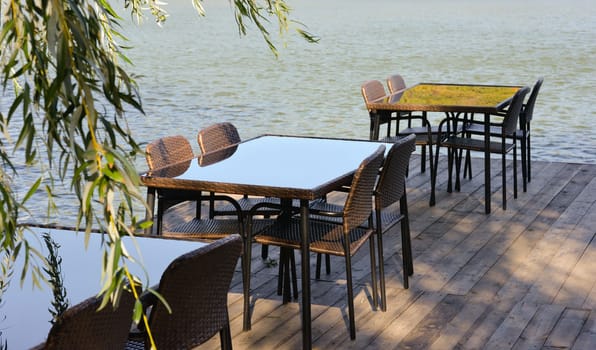 Recreation area in the city park. Outdoor tables and benches by the lake for relaxing and eating.