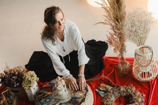 Women's circle and practice in the use of metaphorical cards. The girl is sitting surrounded by flowers.