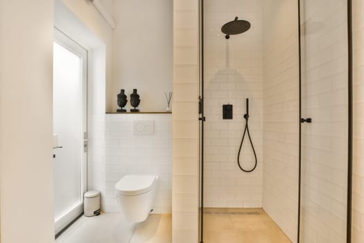 a modern bathroom with white tiles and black fixtures in the shower stall, which is also used as a toilet