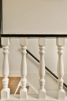 a staircase with white railings and black handrails on the stairs in an empty room is behind it