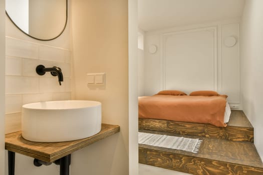 a bathroom with a sink, mirror and toilet paper on the counter in the photo is taken to the right