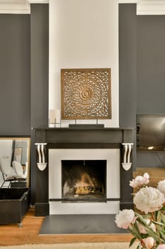 a living room with a fire place and flowers in the vase on the coffee table next to the fireplace mantel