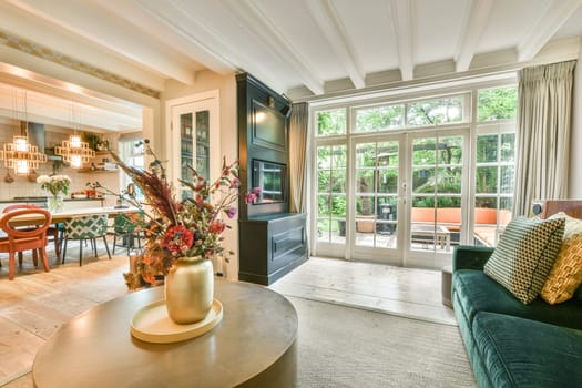 a living room with couches, chairs and a coffee table in the center of the room is decorated with flowers