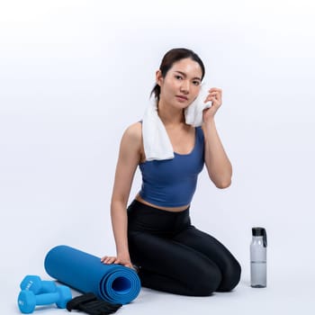 Athletic and sporty asian woman resting after intensive cardio workout training. Healthy exercising and fit body care lifestyle pursuit in studio shot isolated background. Vigorous