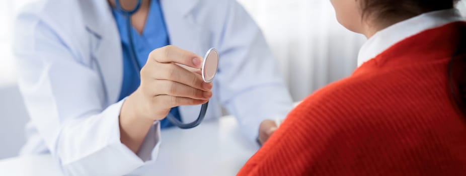 Patient attend doctor's appointment at clinic or hospital office. Doctor examining and diagnosis symptoms while checking the patient's pulse with stethoscope. Panorama Rigid