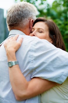 Senior couple, garden and a hug for commitment, care and bonding together in retirement. Comfort, elderly and a man and woman with affection, romance or loyalty in a marriage in a park for a date.