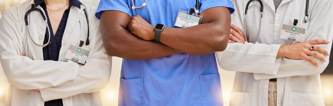 Doctors, healthcare and team with arms crossed in a hospital for teamwork and collaboration. Diversity, group and professional man and women with stethoscope and name tag for career in medicine.