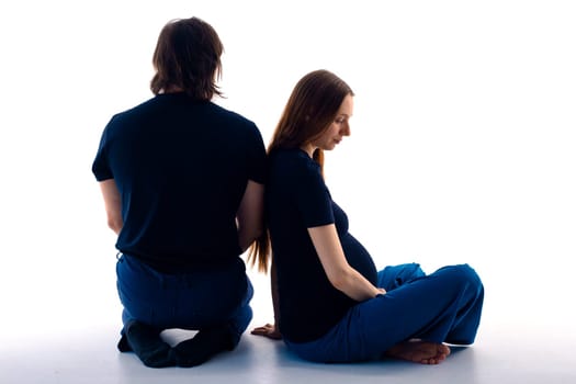 Photo of cheerful young man standing with his pregnant woman isolated over white background wall. beautiful young couple expecting baby standing together and touching belly