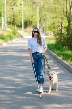 Blind woman walking with guide dog in the park