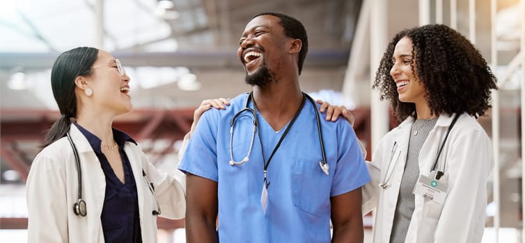 Doctors, healthcare and medical team laughing together in a hospital with teamwork and collaboration. Diversity, happy and professional man and women with support, funny joke and career in medicine.