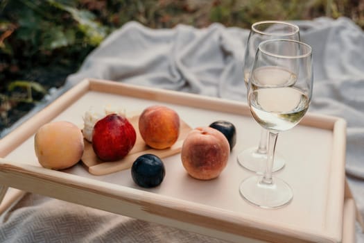 Picnic and wine tasting at sunset in the hills of Italy, Tuscany. Vineyards and open nature in the summer. Romantic dinner, fruit and wine.