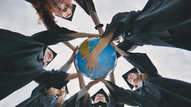 Graduating students embrace a geographical globe of the world. The concept of preserving peace