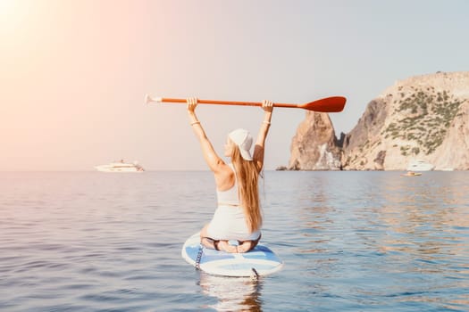 Close up shot of beautiful young caucasian woman with black hair and freckles looking at camera and smiling. Cute woman portrait in a pink bikini posing on a volcanic rock high above the sea