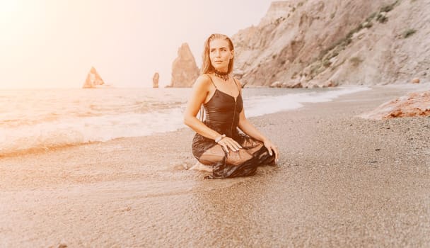 Woman travel sea. Young Happy woman in a long red dress posing on a beach near the sea on background of volcanic rocks, like in Iceland, sharing travel adventure journey