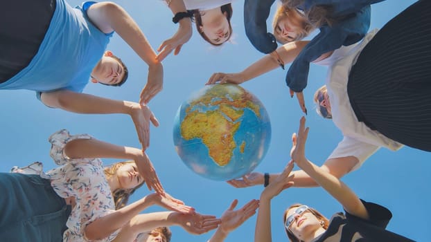 Young boys surround the globe of the world with their palms