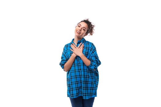 a young caucasian brunette woman with her hair gathered in a bun is dressed in a blue shirt.