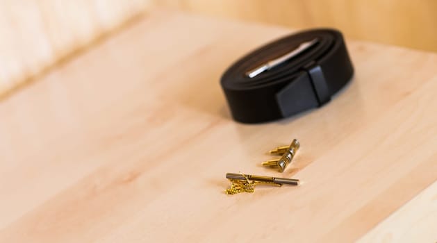 men's leather belt and cufflinks on the table. Men's accessories.