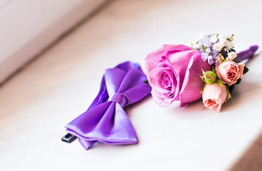 Gentle groom's boutonniere and bow-tie. Wedding accessories for a groom