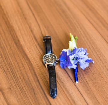 Gentle groom's boutonniere and watch. Wedding accessories for a groom