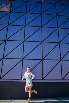 a fashionable woman near the big glass wall of the building