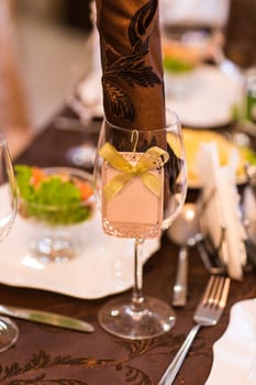 Wedding table. Close-up of wine glass and name card