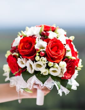 Beautiful wedding bouquet in hands of the bride.