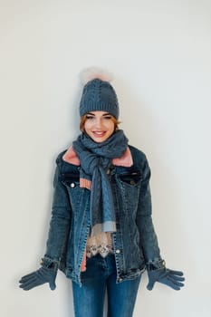 a woman in winter clothes in a hat stands in a bright room