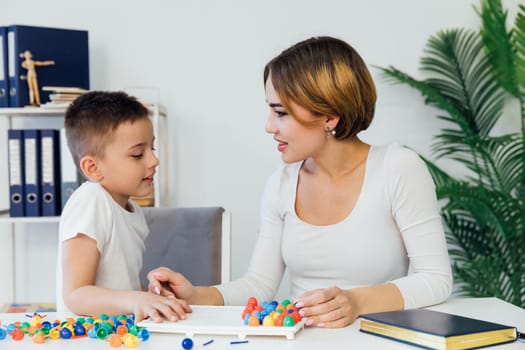 boy with a female psychologist in the office plays educational games