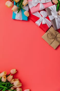 a tulips with gifts on a red background for the holiday